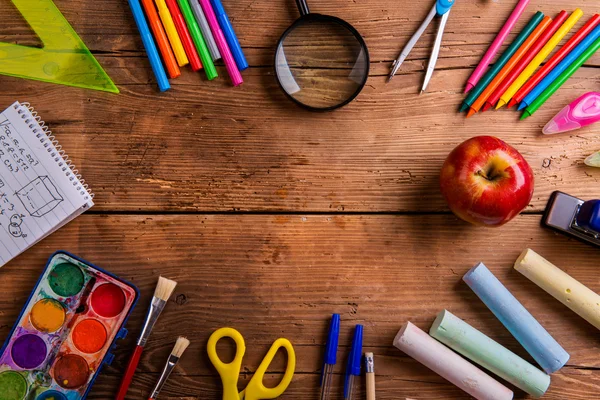 Desk with school supplies against wooden background, copy space — ストック写真