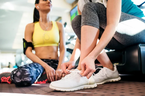 Two attractive fit women in gym preparing for workout — 스톡 사진