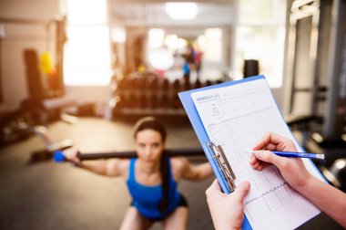 spor salonunda antrenör ile egzersiz kadın