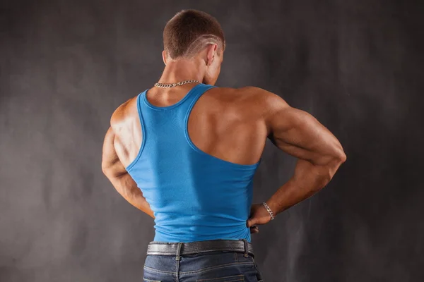 Fisiculturista em jeans e uma camiseta azul — Fotografia de Stock