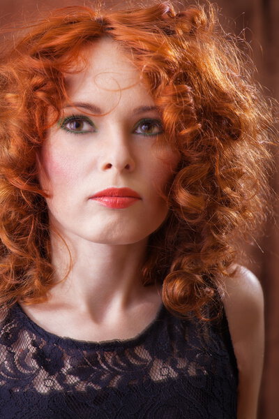 Red Hair. Beautiful Woman with Curly Long Hair.