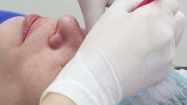 Cosmetologist que aplica a composição permanente (tatuagem) em sobrancelhas . — Vídeo de Stock