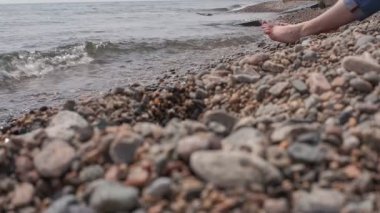 Kız Baykal kıyı üzerinde oturur.