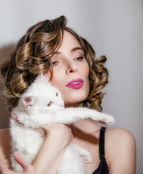Mooi meisje met een witte pluizige kat in haar armen. — Stockfoto