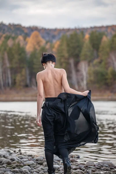 Woman in black near river — Stock Photo, Image