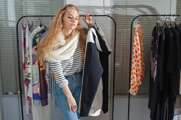 Girl chooses clothes in a boutique. Stock Image