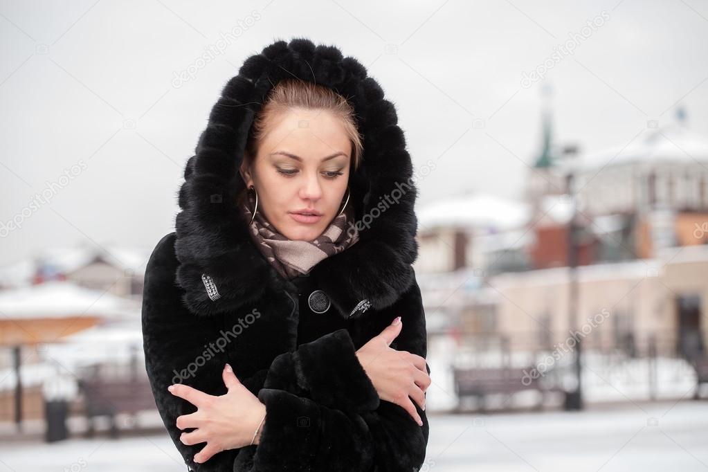 Sad beautiful girl in a fur coat.