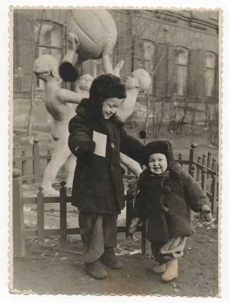 Két fiú, a háttérben a szobor télen. — Stock Fotó