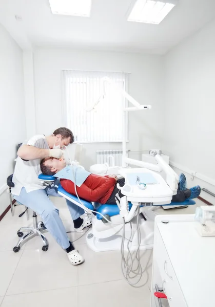 Tandläkare gör tandvård till patienten. — Stockfoto