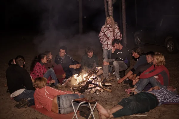 Turistas alrededor de la fogata por la noche . — Foto de Stock