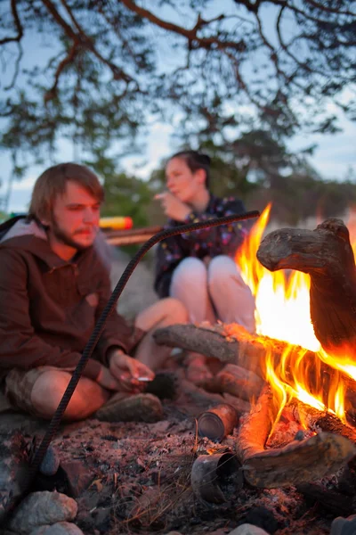 Turistas alrededor de la fogata por la noche . — Foto de Stock