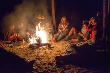gece kamp ateşi etrafında turist.