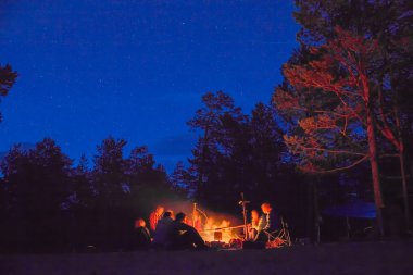 gece kamp ateşi etrafında turist.