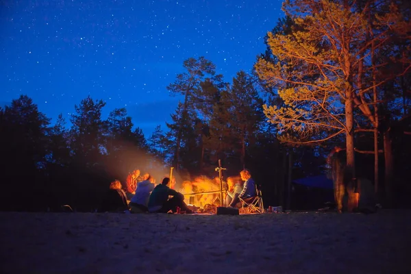 Tourists around the campfire at night. — Stock Photo, Image