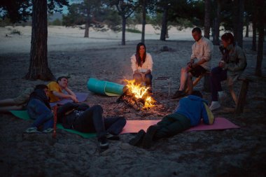 gece kamp ateşi etrafında turist.