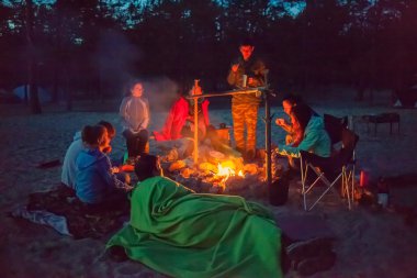 gece kamp ateşi etrafında turist.