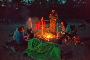 gece kamp ateşi etrafında turist.
