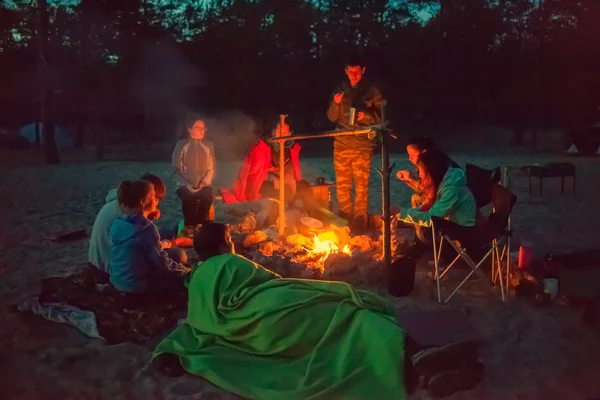 Tourists around the campfire at night. — Stock Photo, Image