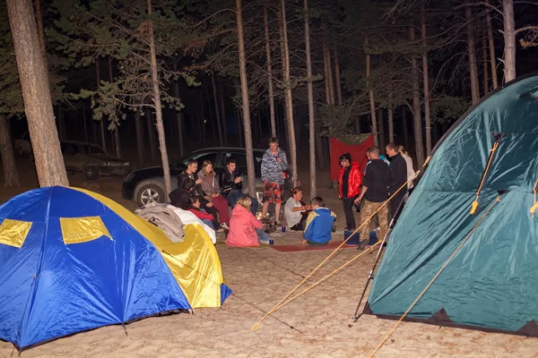 Turistas ao redor da fogueira à noite . — Fotografia de Stock