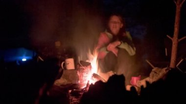 gece kamp ateşi etrafında turist.