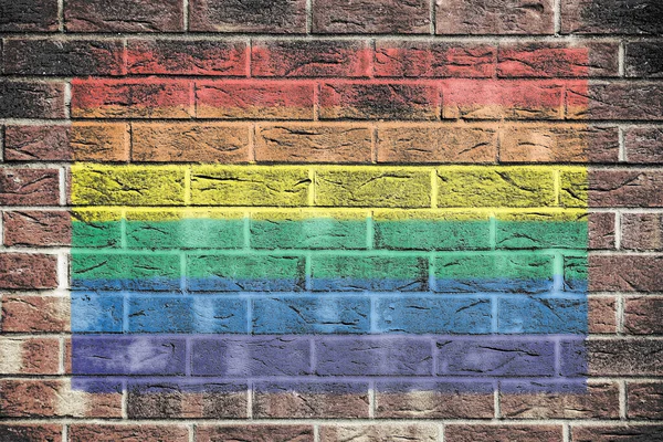 レンガの壁の背景にゲイの誇り虹の旗 — ストック写真