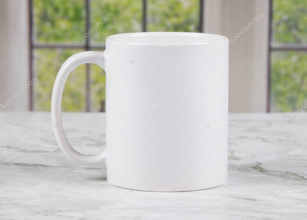 White coffee mug with copy space on marble kitchen surface with windows in background