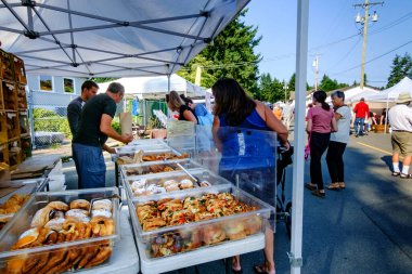 21 Ağustos 2021 - Kanada 'daki Qualicum Beach: Yerel çiftçi pazarındaki Bodhis Esnaf Fırını' ndan ekmek satın alan müşteriler