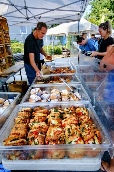 21 Ağustos 2021 - Kanada 'daki Qualicum Beach: Yerel çiftçi pazarındaki Bodhis Esnaf Fırını' ndan ekmek satın alan müşteriler