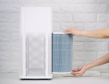 Replace the air purifier filter in the house. clipart