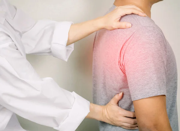 The doctor examines a patient with back pain Inflammation of the back