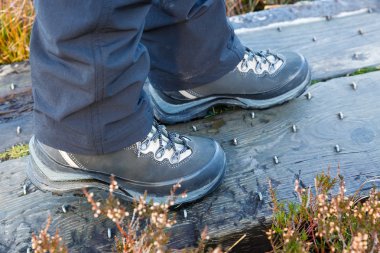 Hiking boots on studded wooden footbridge clipart