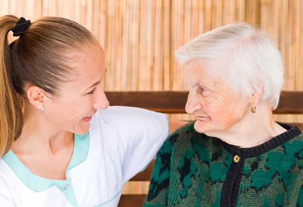 Elderly woman with caregiver — Stock Photo, Image