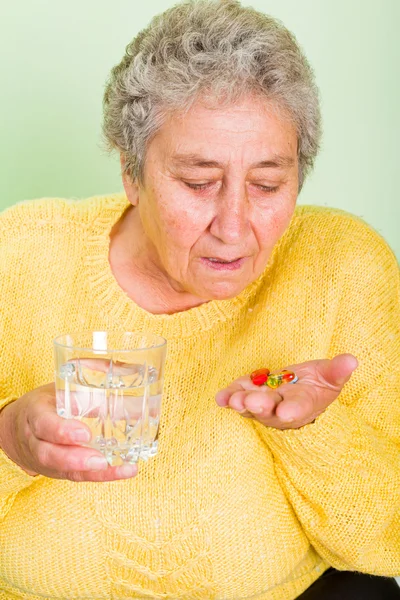 Пожилая женщина принимает ежедневные таблетки — стоковое фото