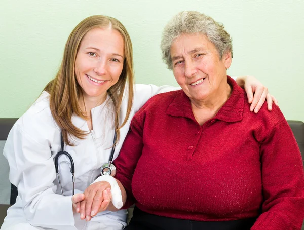 Elderly woman and young doctor — Stock Photo, Image