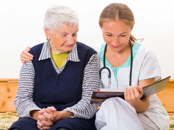 Elderly woman and young doctor — Stock Photo, Image
