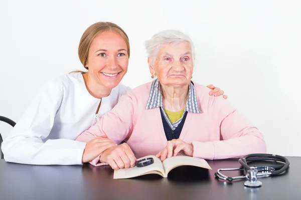 Elderly woman and young doctor — Stock Photo, Image