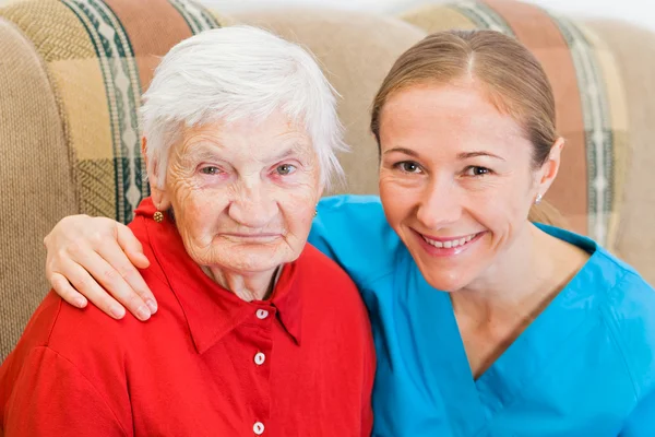 Ältere Frau und junge Pflegerin — Stockfoto