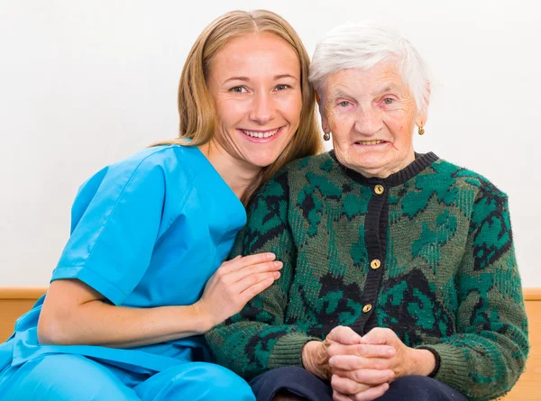 Oudere vrouw en jonge dokter — Stockfoto