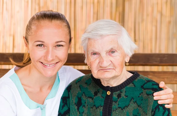 Mujer anciana con cuidador — Foto de Stock