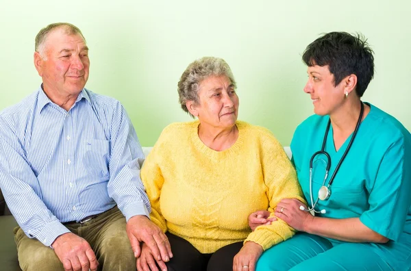 Photo of happy elderly couple with the doctor — Stock Photo, Image