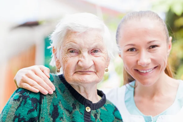 Mujer anciana con cuidador — Foto de Stock