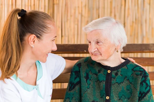 Mujer anciana con cuidador — Foto de Stock