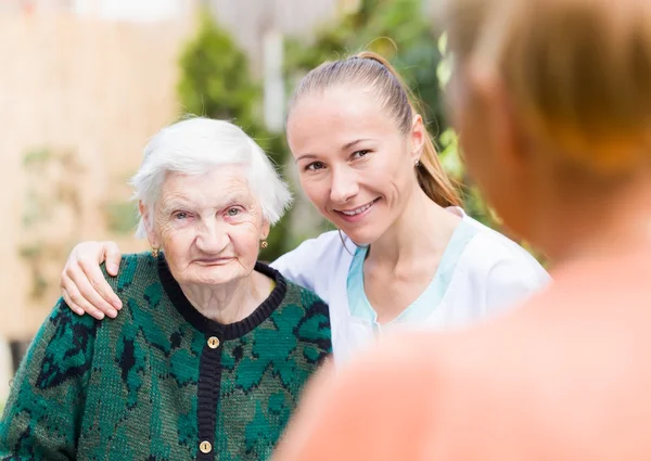 Elderly woman with caregiver — Stock Photo, Image