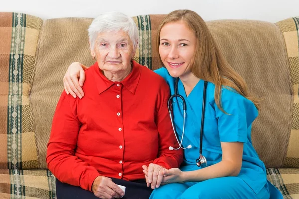 Elderly woman and young doctor — Stock Photo, Image