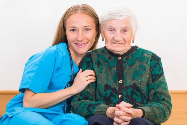 Elderly woman and young doctor — Stock Photo, Image