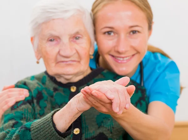 Elderly woman and young doctor — Stock Photo, Image