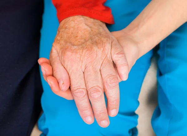 Νέος γιατρός, δίνοντας τα χέρια βοηθείας για την ηλικιωμένη γυναίκα — Φωτογραφία Αρχείου