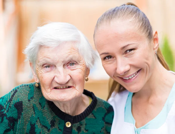 Mujer anciana con cuidador — Foto de Stock