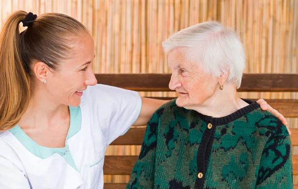 Elderly woman with caregiver — Stock Photo, Image