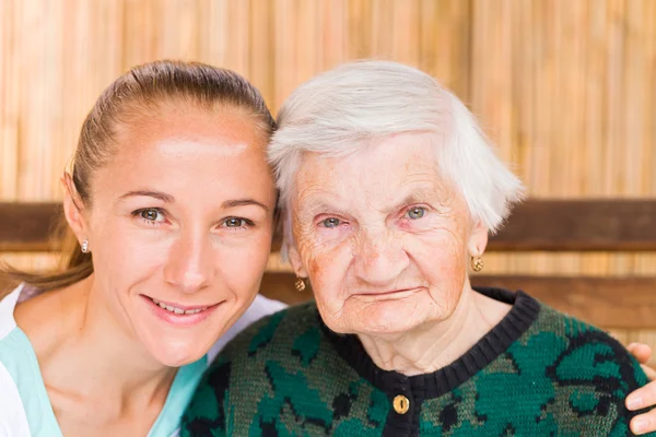 Mujer anciana con cuidador — Foto de Stock